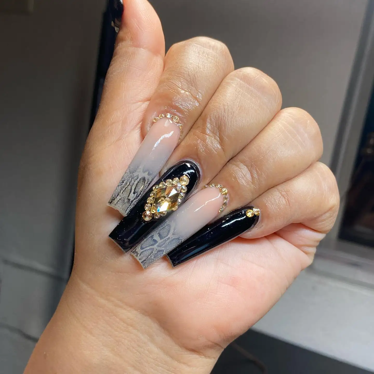 Long coffin-shaped matte gray nails with thin white diagonal lines creating a subtle wrap effect.