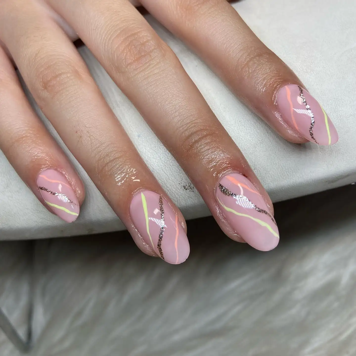 Short square nails with silver glitter French tips, white wrap detailing, and one accent nail featuring cartoonish black eyes.