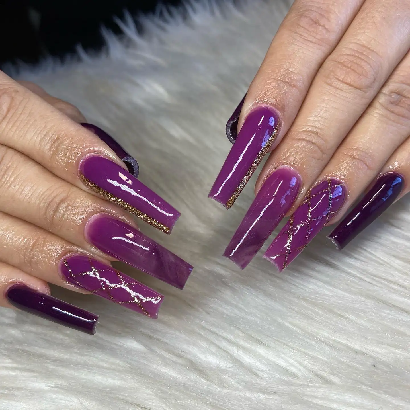 Long almond nails with metallic pink base and wrap detailing, featuring black cat-style eyes on two accent nails.