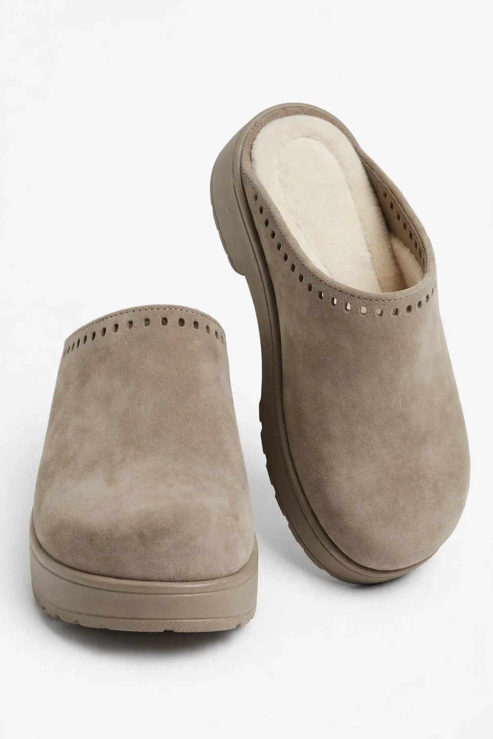 Pair of taupe-beige suede closed-toe clogs on a white background with plush cream insoles
