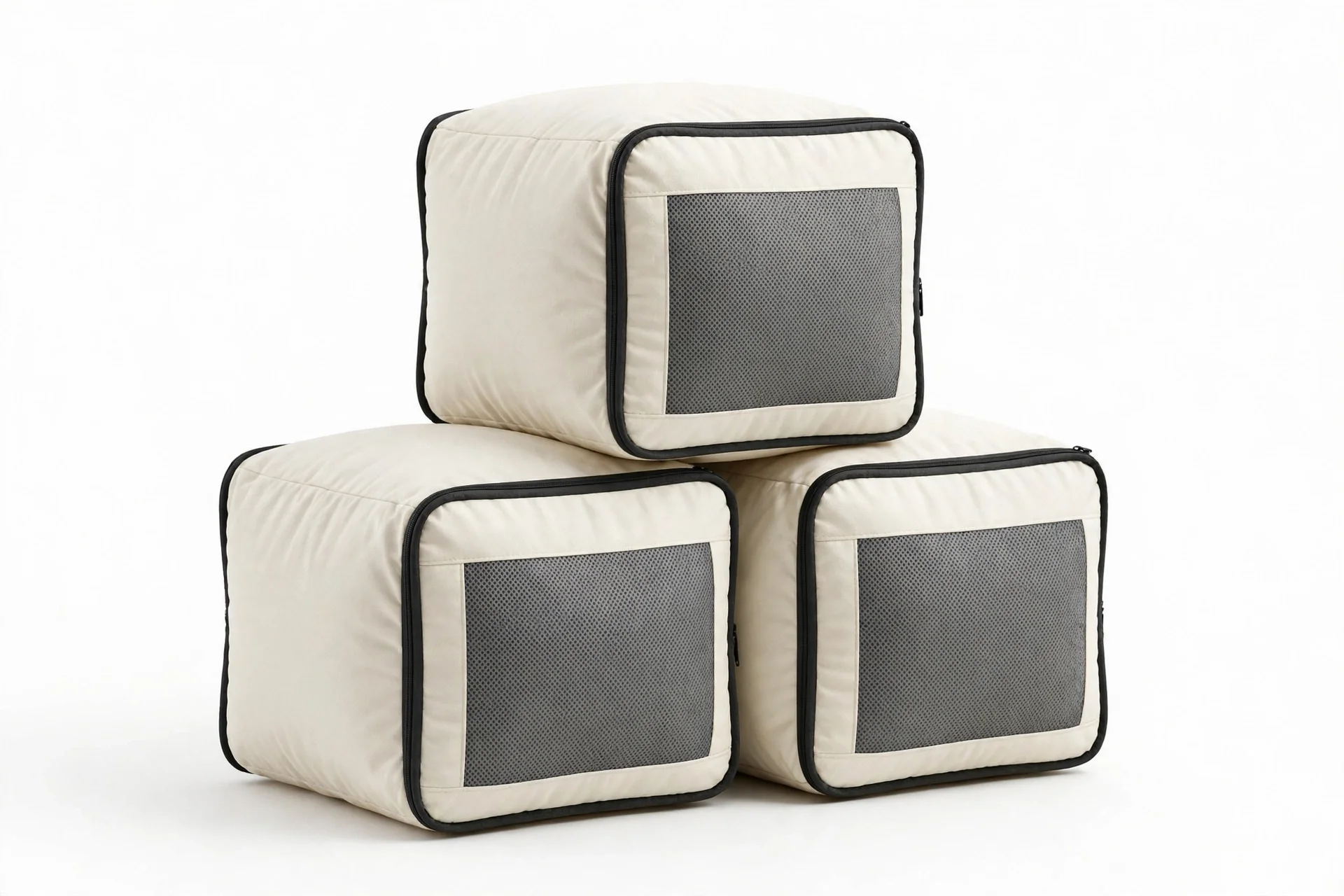 Three cream off-white packing cubes with black trim and grey mesh panels, grouped and stacked