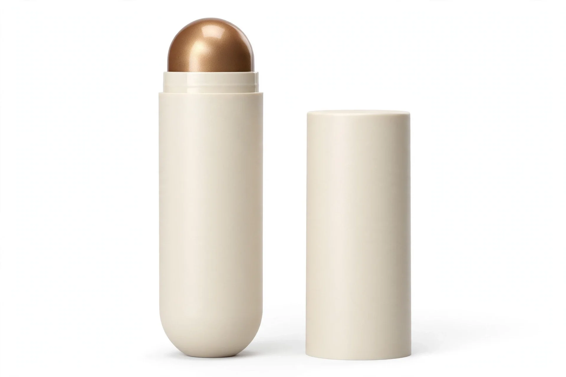 Cream off-white stick tube with a shimmery bronze-gold dome tip exposed, with its matching cream cap standing beside it