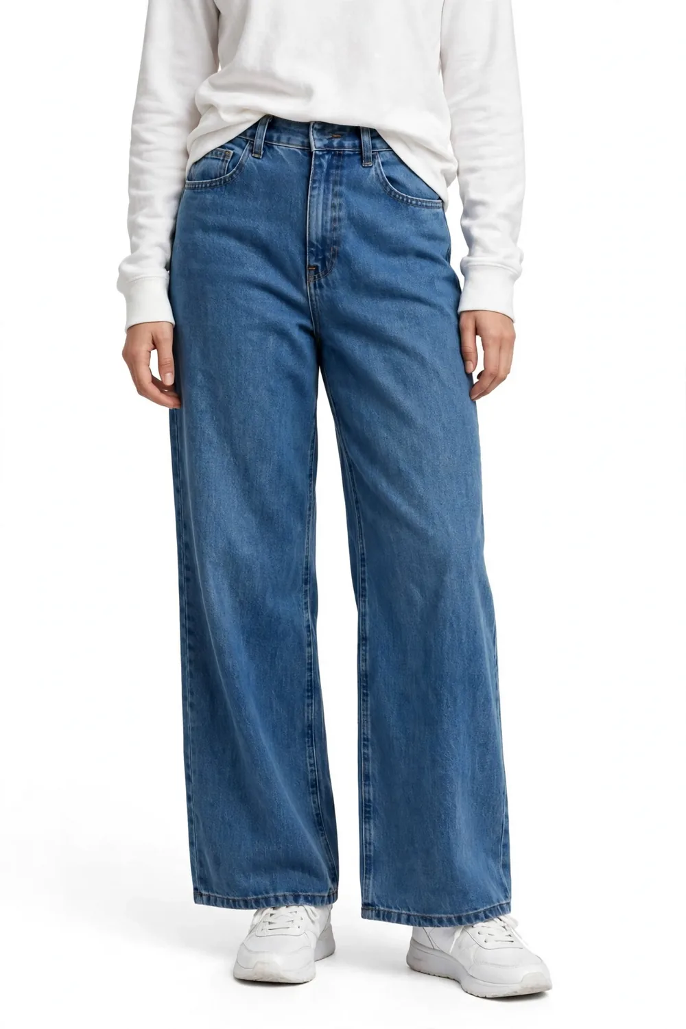 Model from the chest down wearing a white long-sleeved top, medium-blue high-waisted wide-leg stretch pants that look like jeans, and white sneakers, on a white background