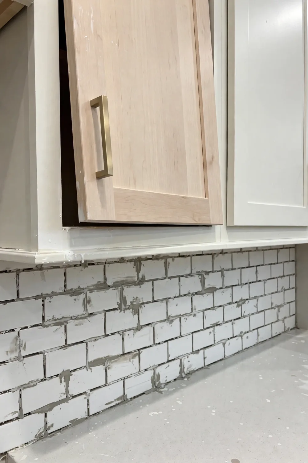 A brand-new kitchen with a slightly crooked cabinet door and uneven grout