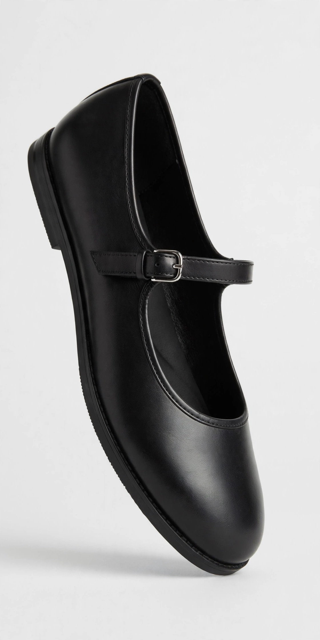 Black women's Mary Jane flat with a strap across the instep, product photo on a light background