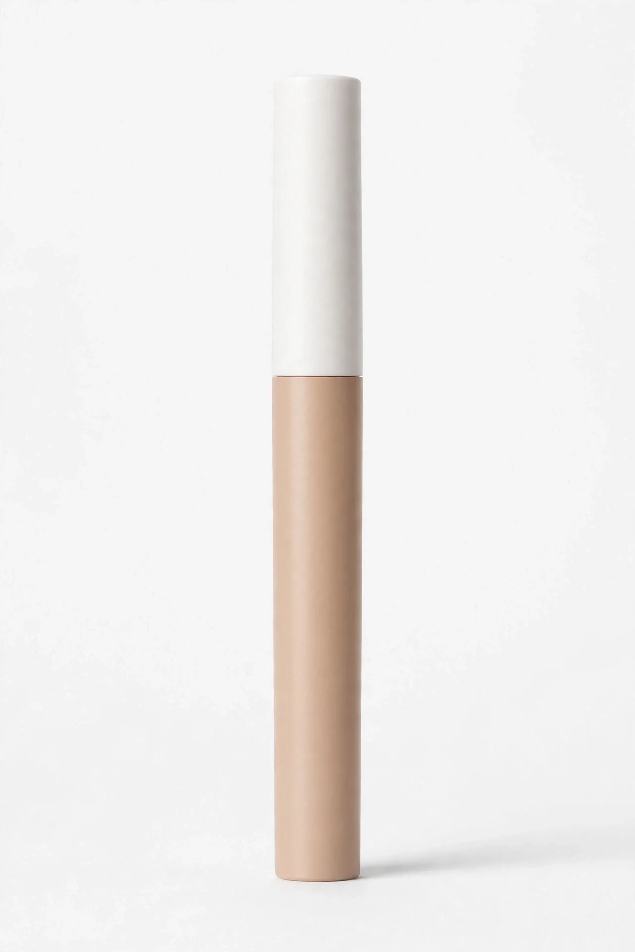 Slim vertical concealer pencil with a long white cap and a beige lower body on a white background