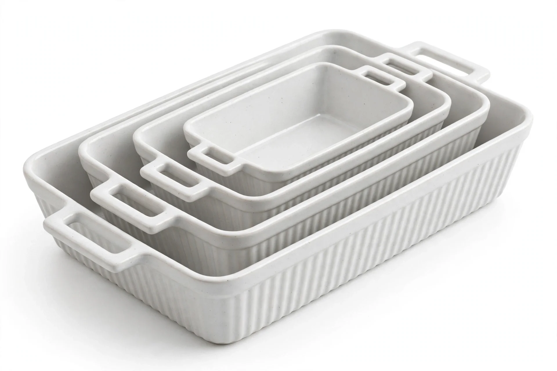 Four nested white ribbed ceramic casserole dishes in graduated sizes