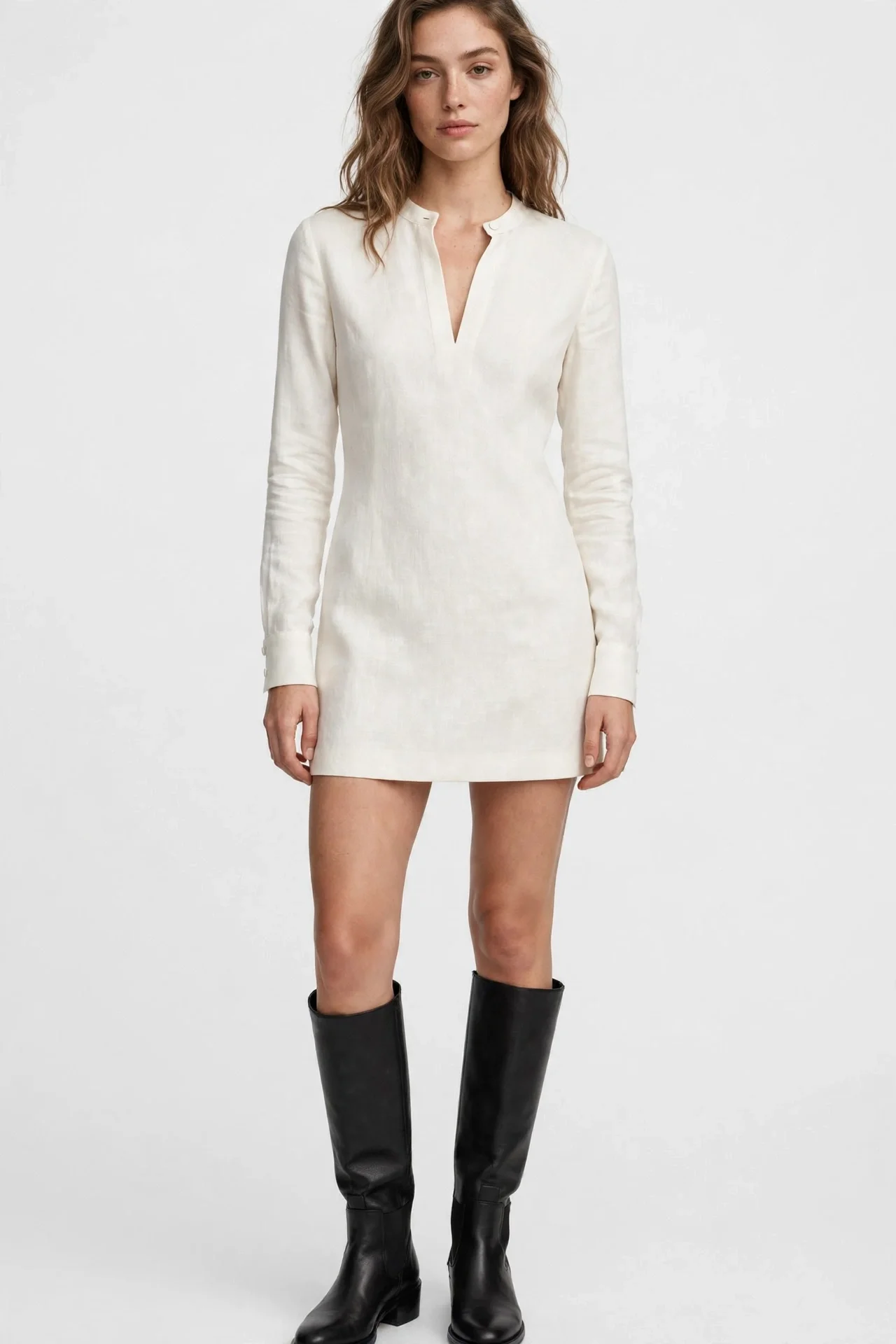 White ivory long-sleeve split-neck mini dress worn with black boots