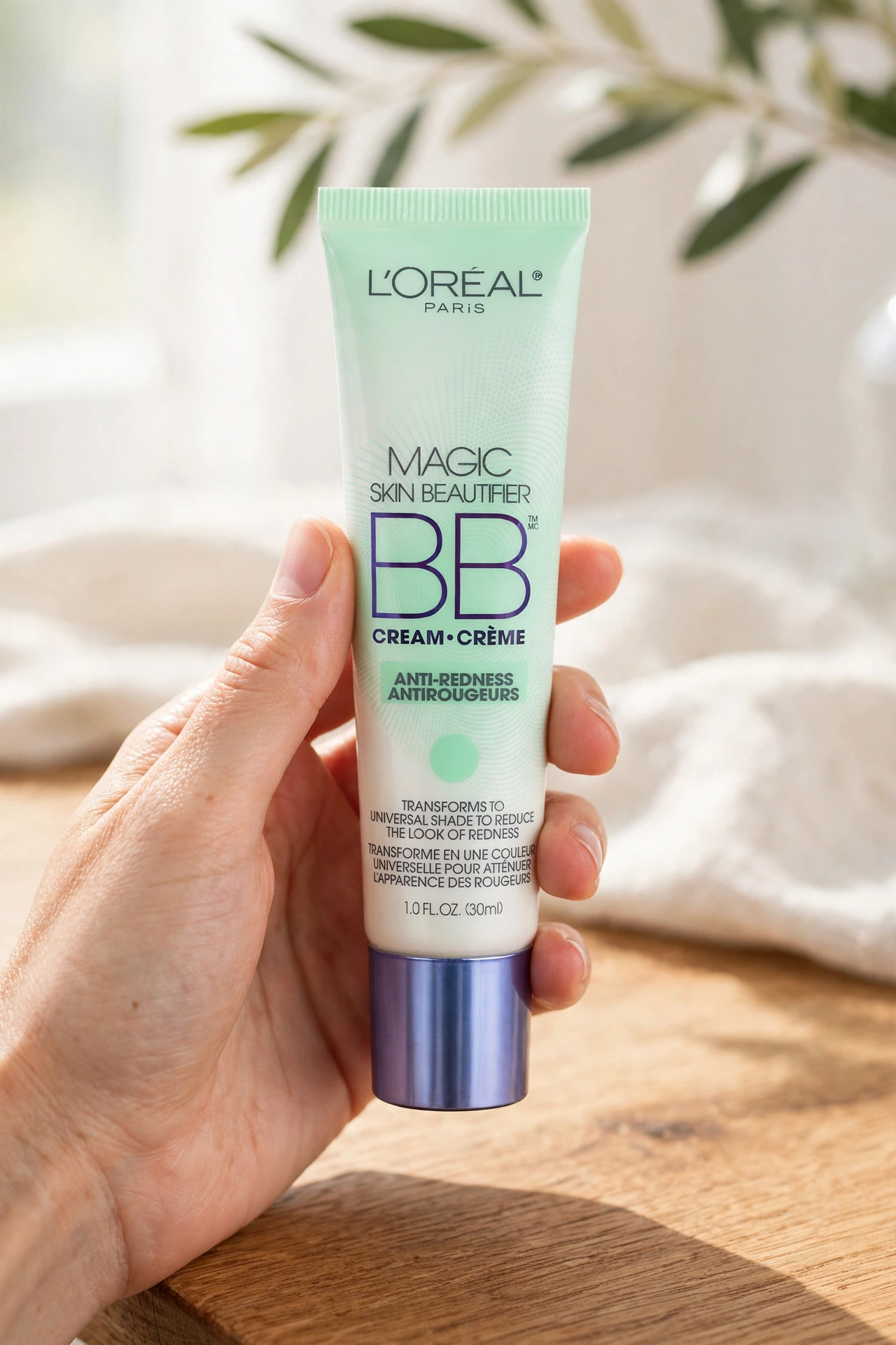 Hand holding a tube of L'Oréal Paris Magic Skin Beautifier BB Cream anti-redness