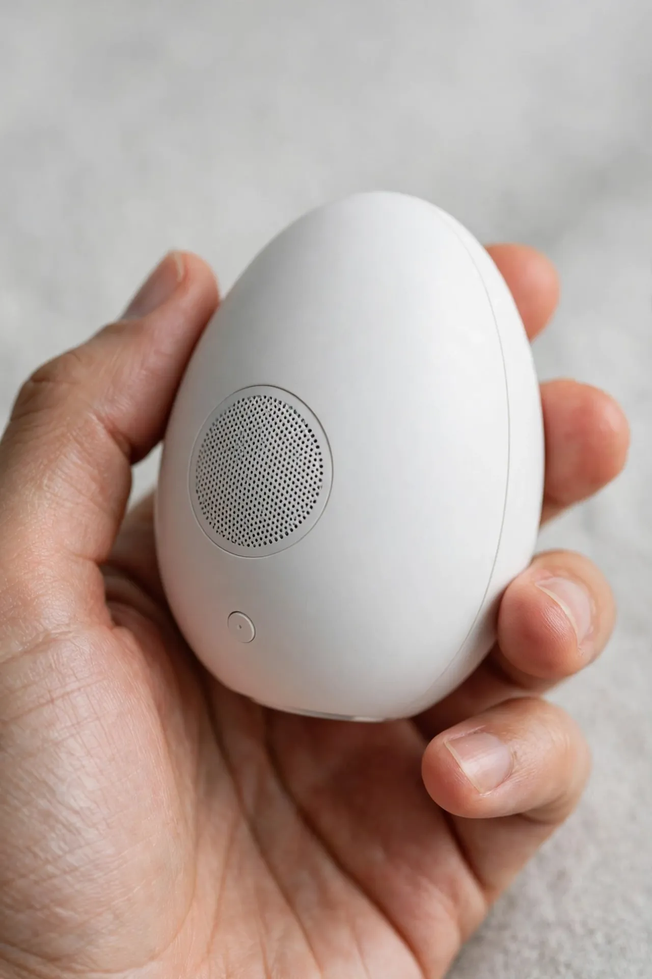 Small egg-shaped white noise machine in a hand