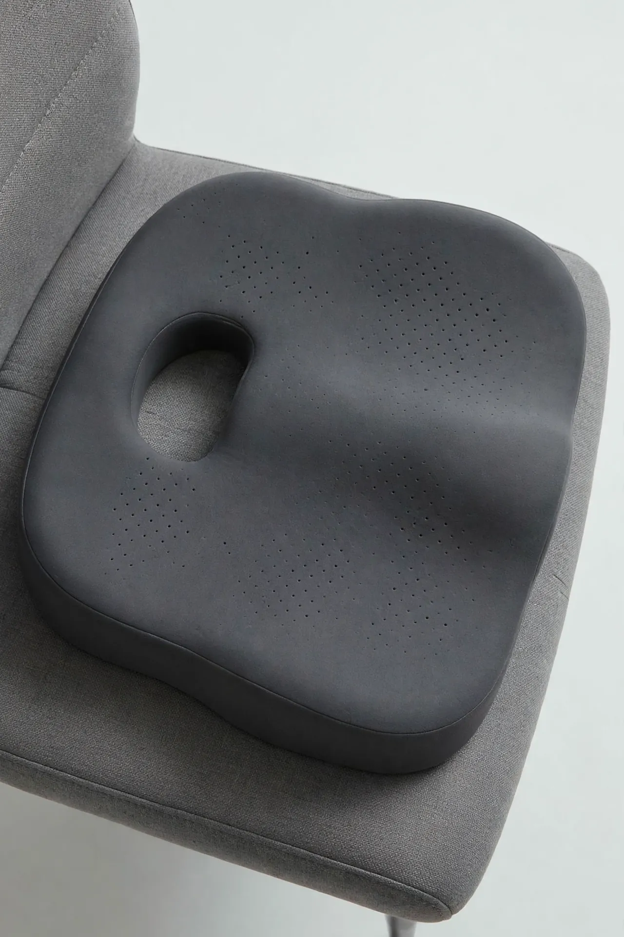 Memory foam seat cushion with tailbone cutout on a seat