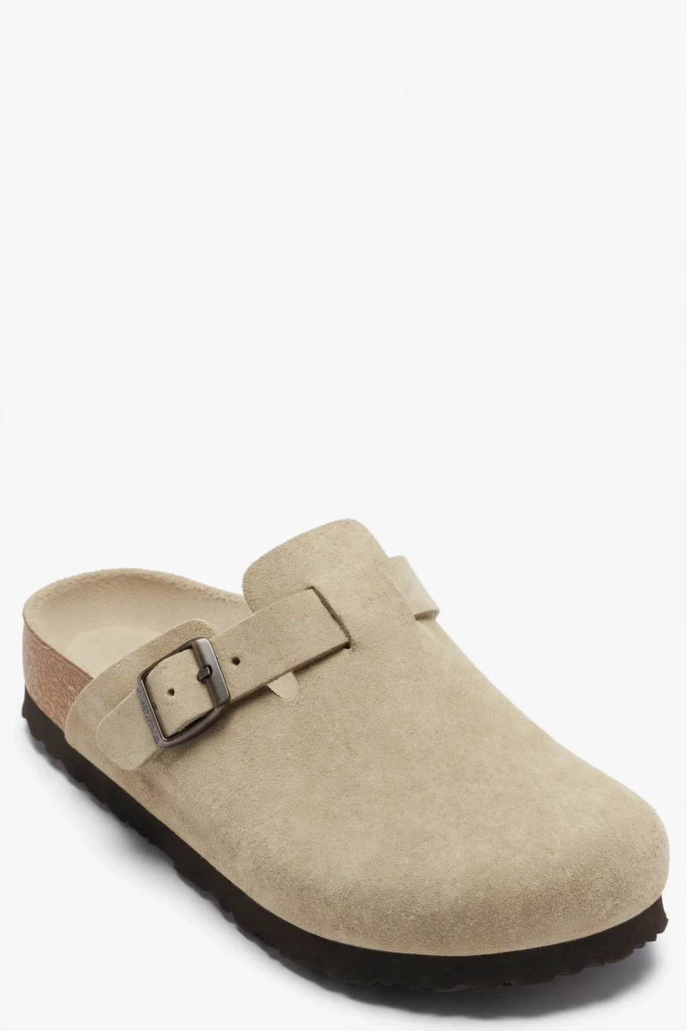 Single light beige-khaki suede clog at an angle with a wide strap, dark metal buckle, cork-style footbed and dark sole